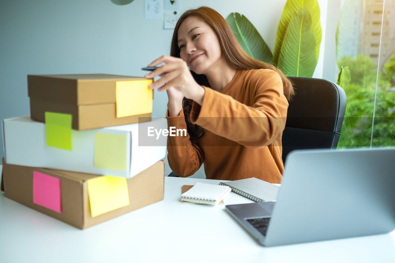 portrait of woman using digital tablet while sitting on table