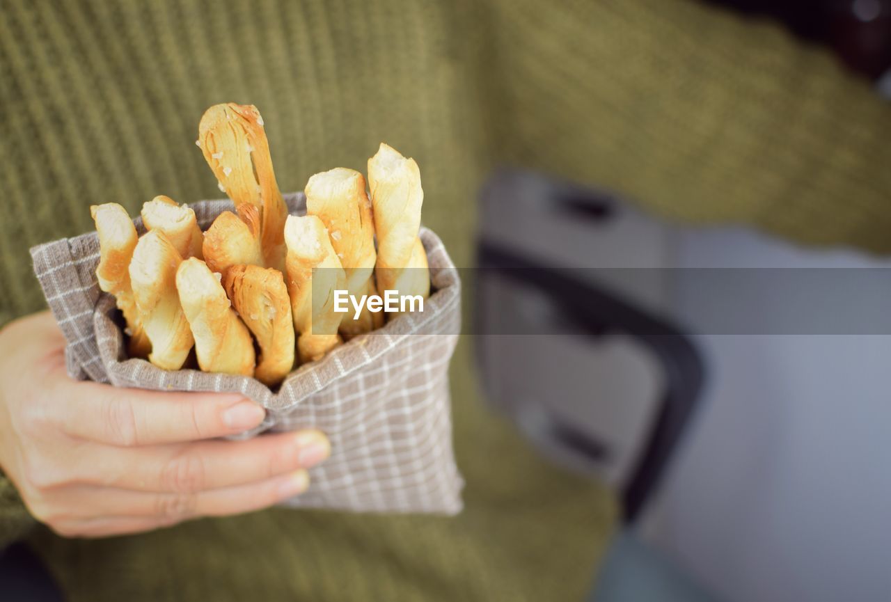 Midsection of person hand holding food