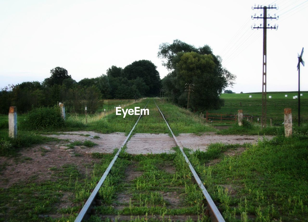 Railroad tracks on field against clear sky