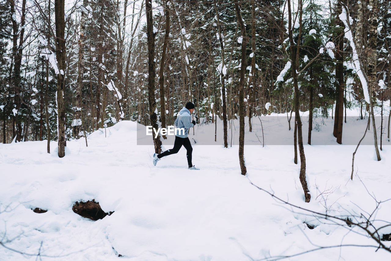 Man running on snow covered field