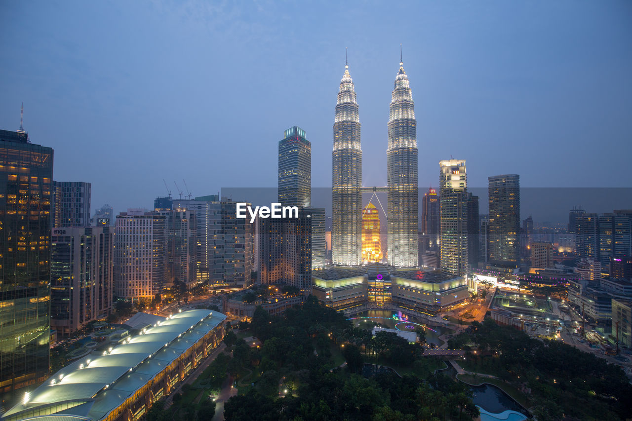 Illuminated buildings in city against sky