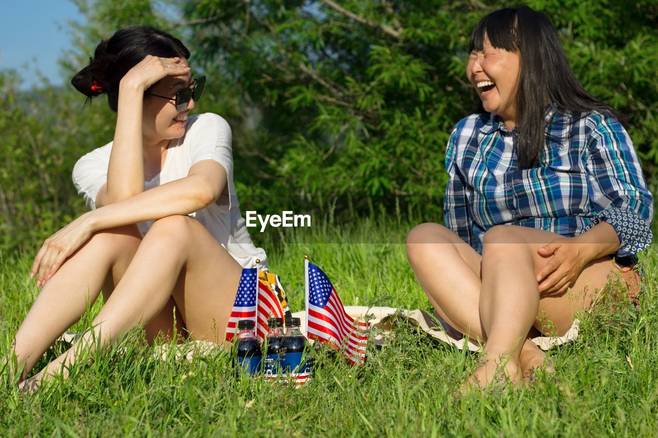 Women with usa flags on lawn, patriotic american national holiday 4th of july independence day