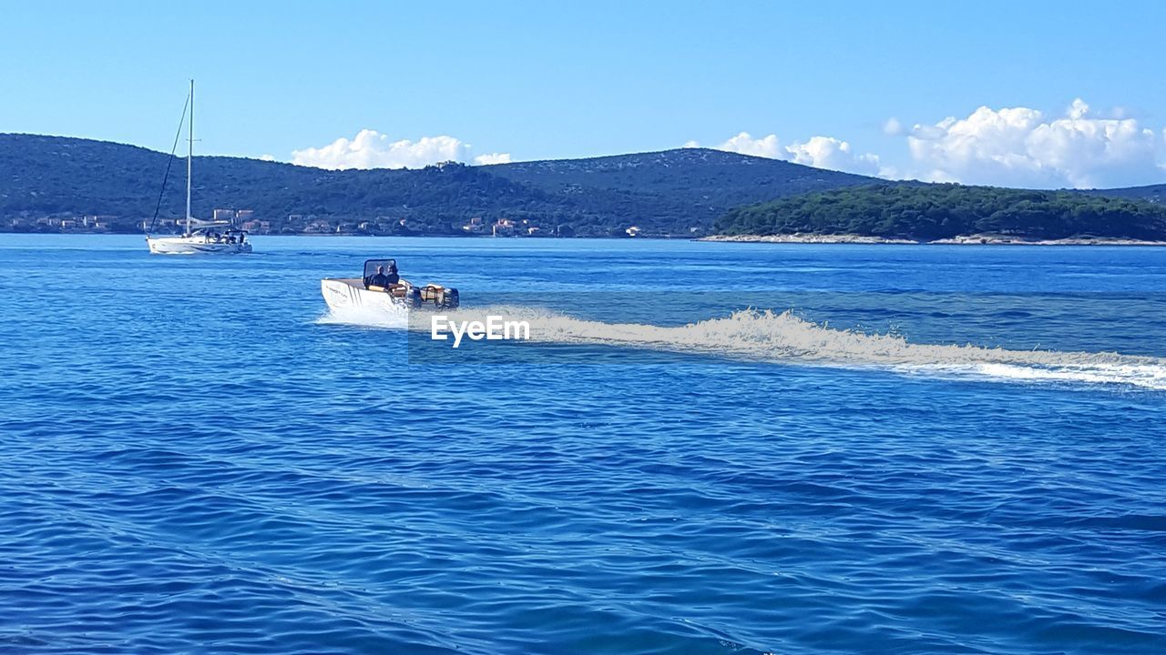 BOATS SAILING ON SEA AGAINST SKY