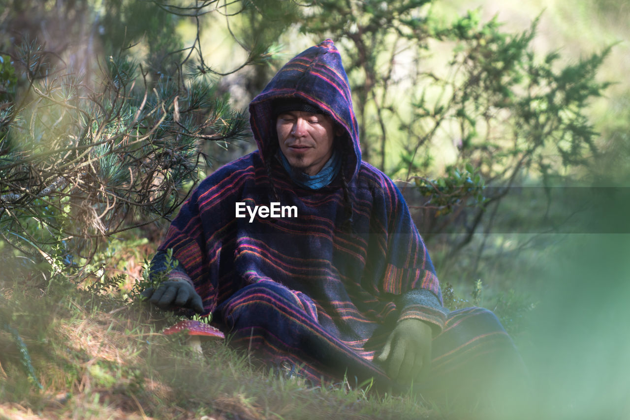 Portrait of colombian native american man in traditional clothing in forest