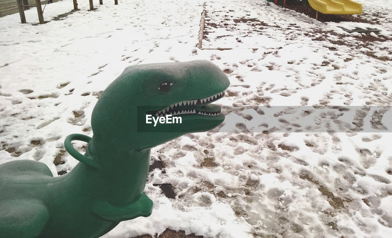 High angle view of dragon sculpture on snow covered field