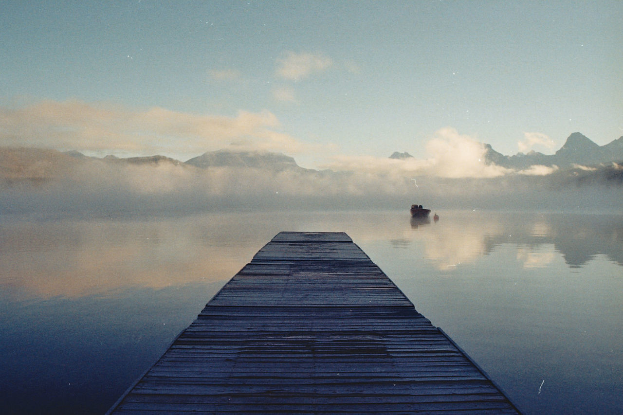 Jetty over lake against sky