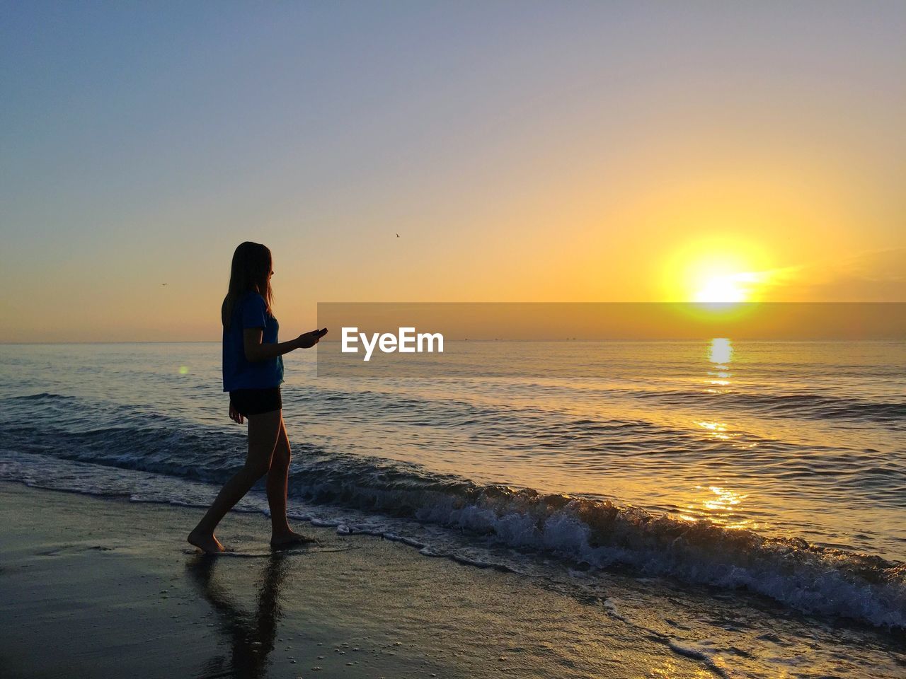 Girl  on beach against sky during sunset