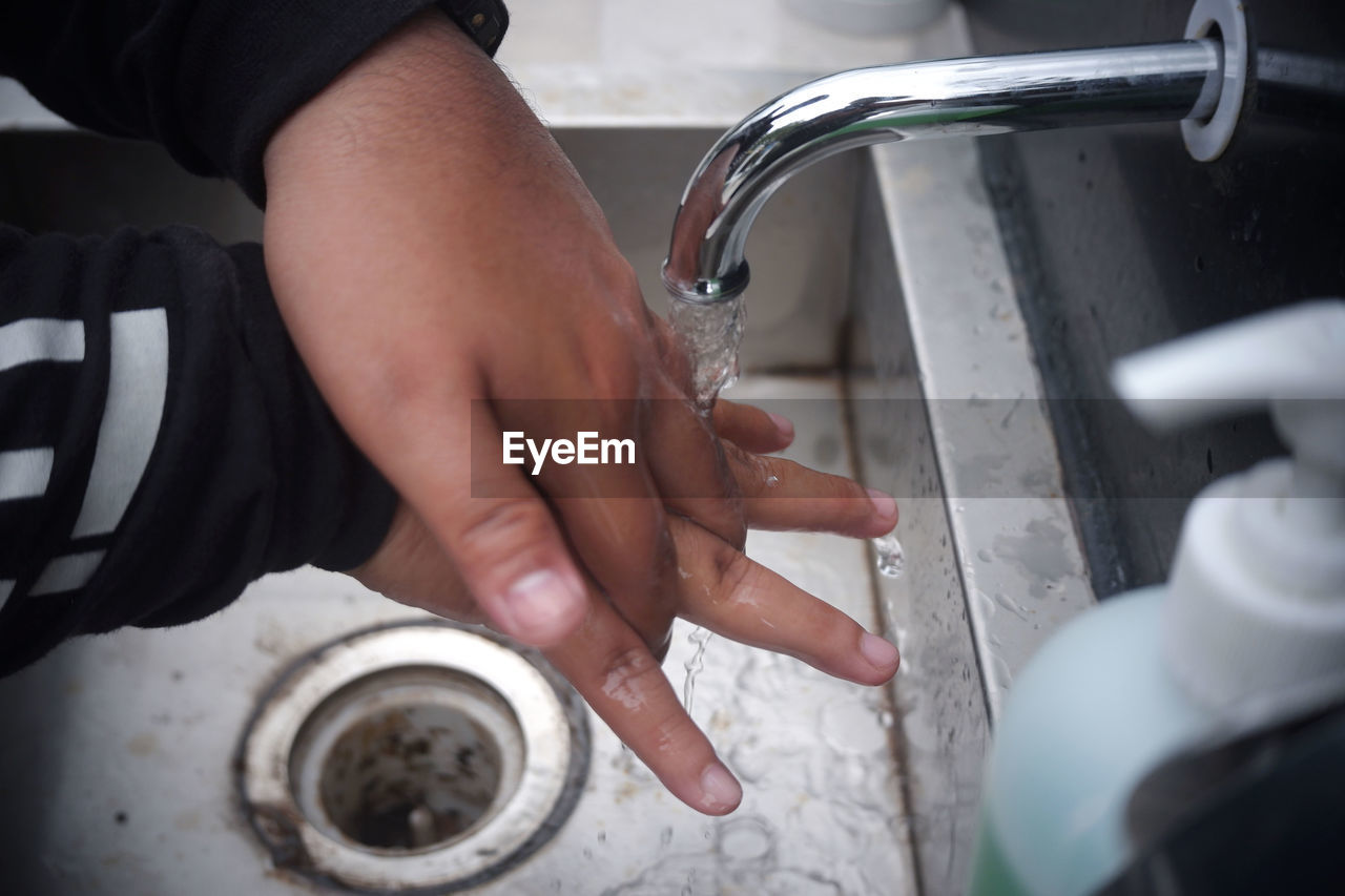 CROPPED IMAGE OF PEOPLE HOLDING HANDS IN WATER