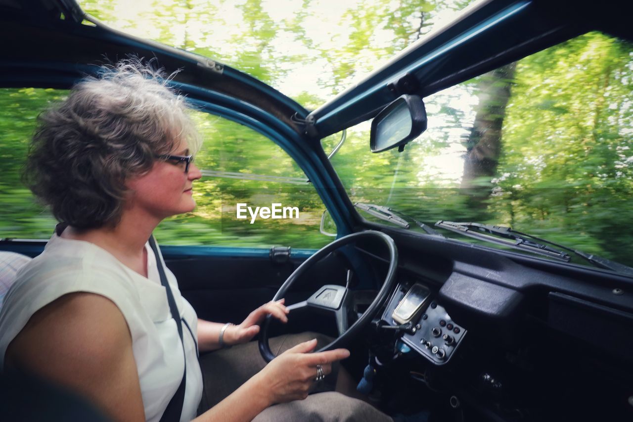 SIDE VIEW OF WOMAN IN CAR