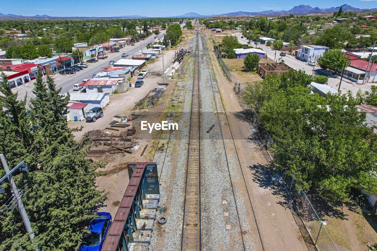 transport, high angle view, transportation, architecture, plant, aerial photography, nature, city, mode of transportation, tree, built structure, residential area, building exterior, track, day, road, outdoors, rail transportation, no people, motor vehicle, building, sky, vehicle, car, train, travel, street, land, railroad track, landscape