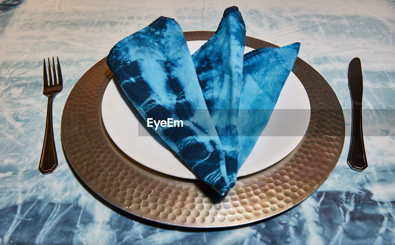 High angle view of blue napkin in plate on table