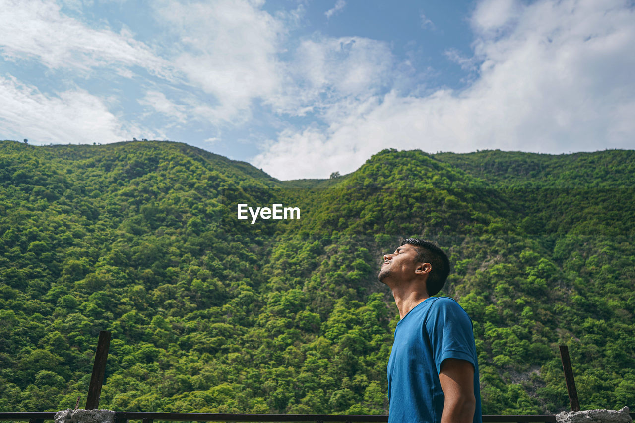 Young indian boy enjoying the view of green mountains.