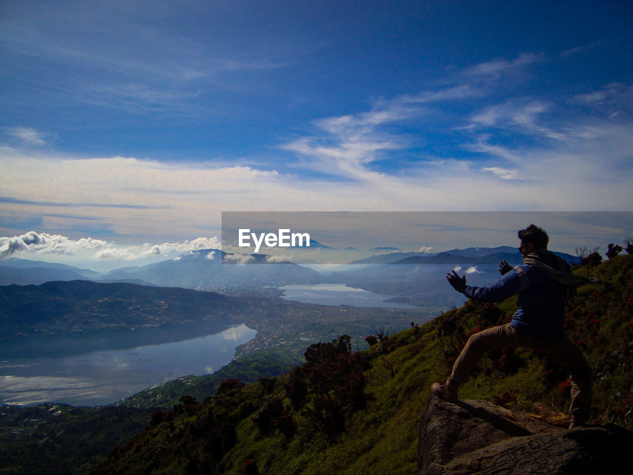 MAN LOOKING AT MOUNTAINS AGAINST SKY