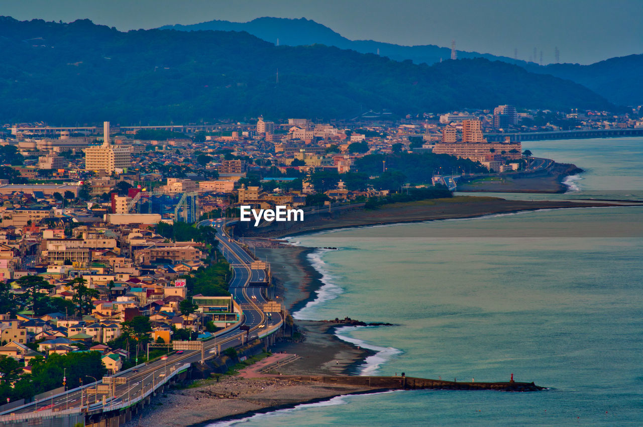 High angle view of townscape by sea against sky