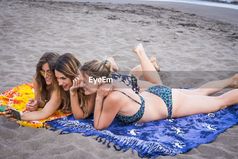 Female friends in bikini taking selfie at | ID: 126509049