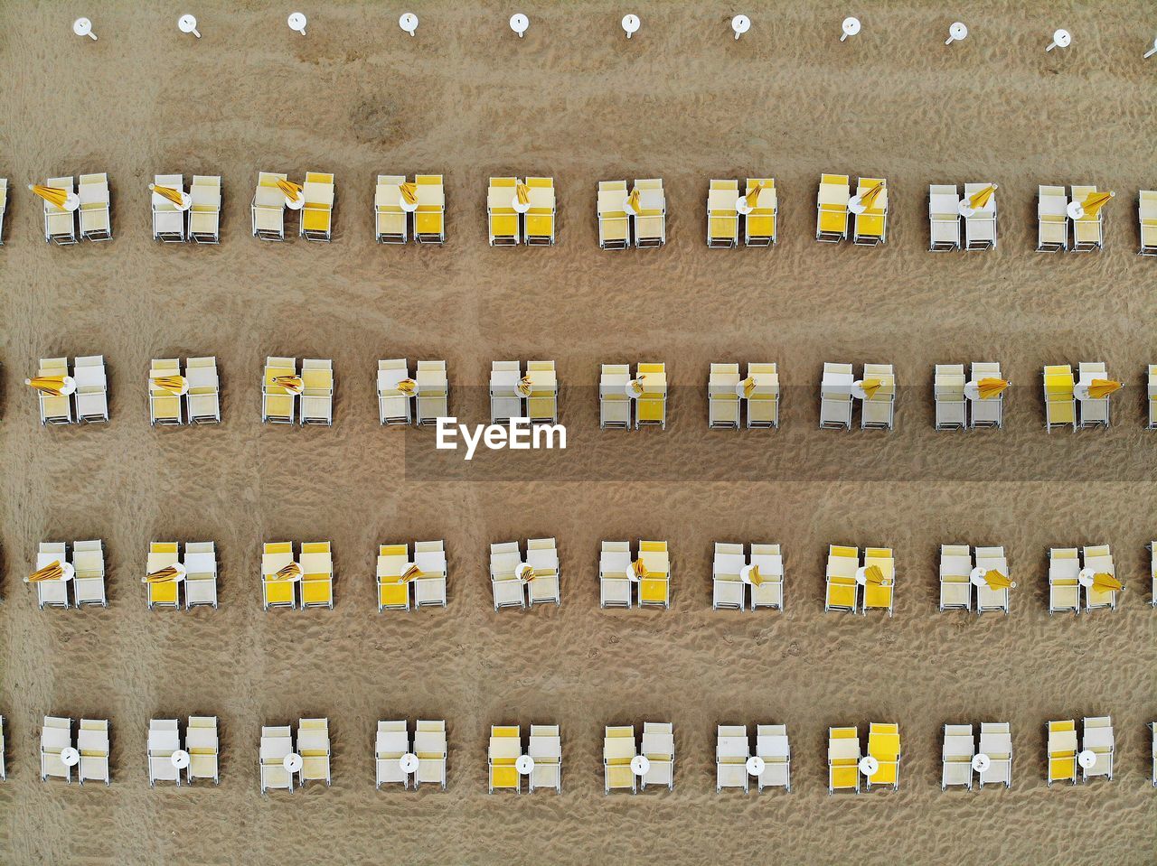 Directly above view of deck chairs on sand at beach