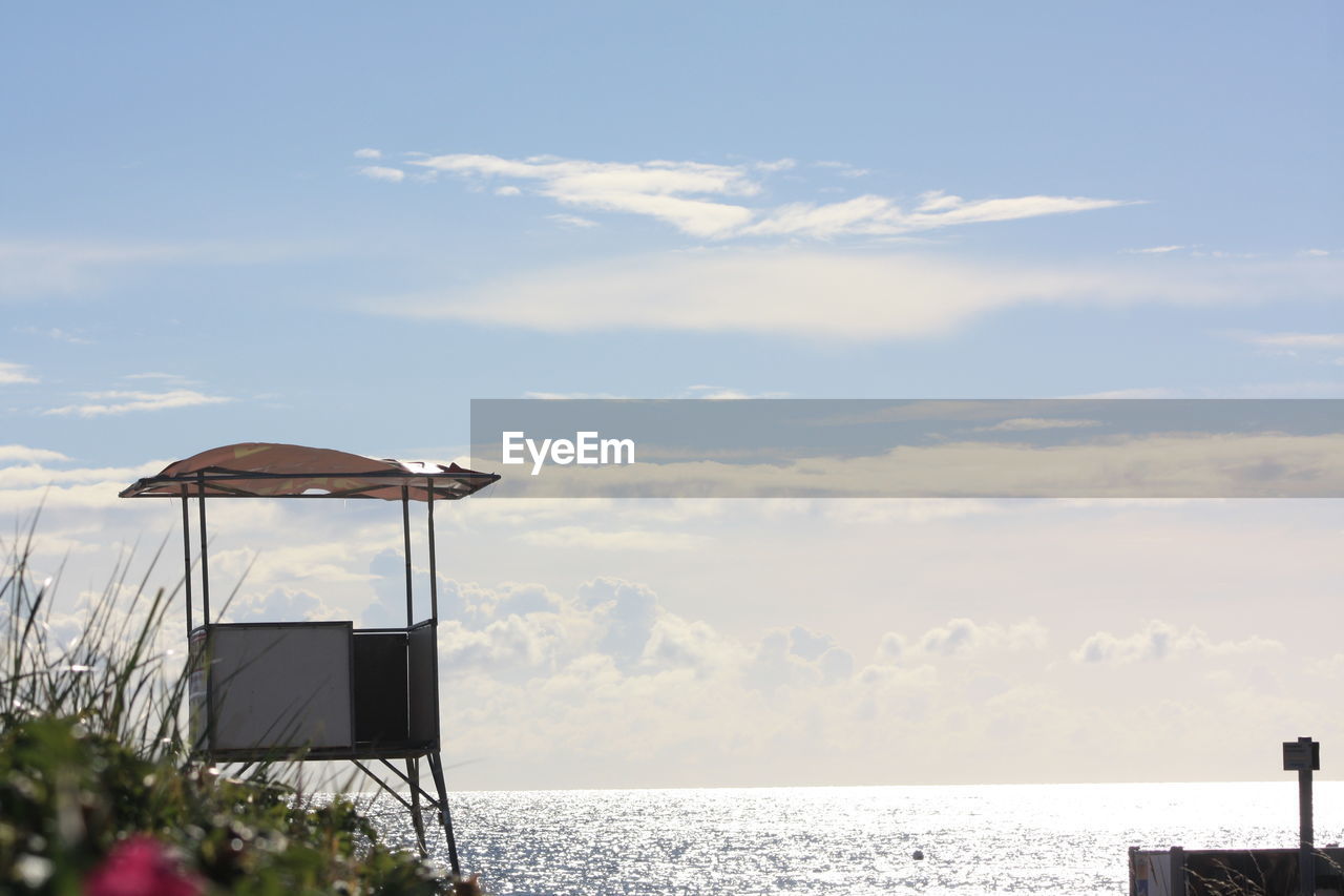 Lifeguard hut at beach against sky