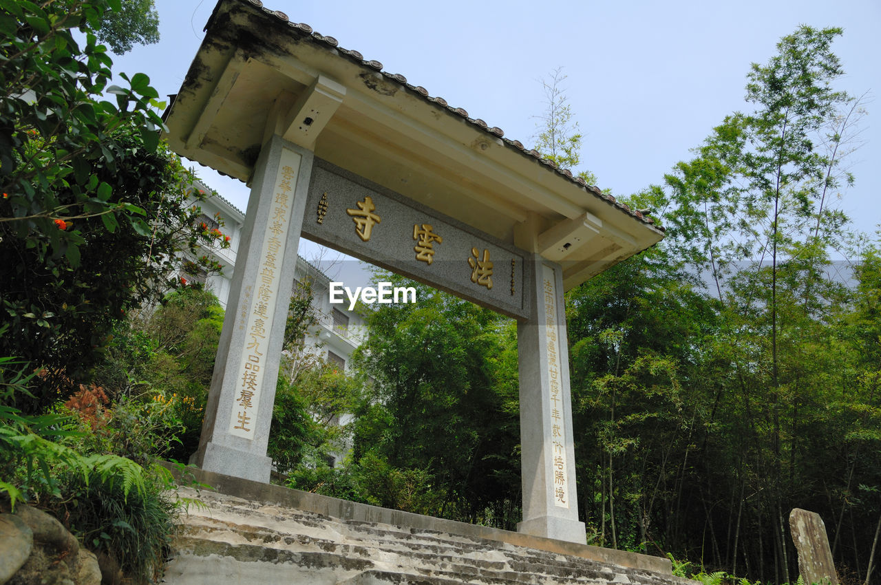 LOW ANGLE VIEW OF INFORMATION SIGN AGAINST TREES