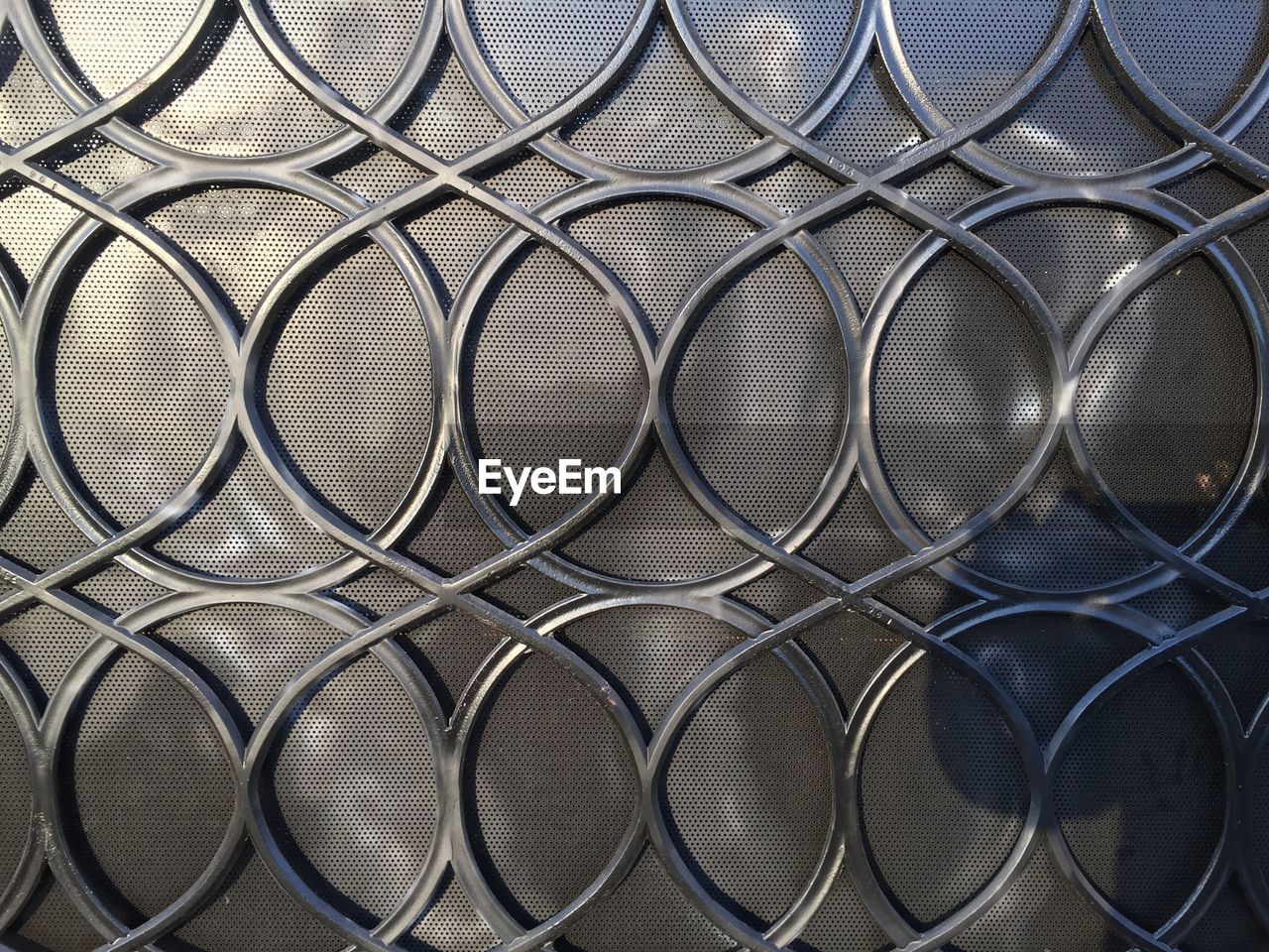 FULL FRAME SHOT OF PATTERNED METAL FENCE AGAINST SKY