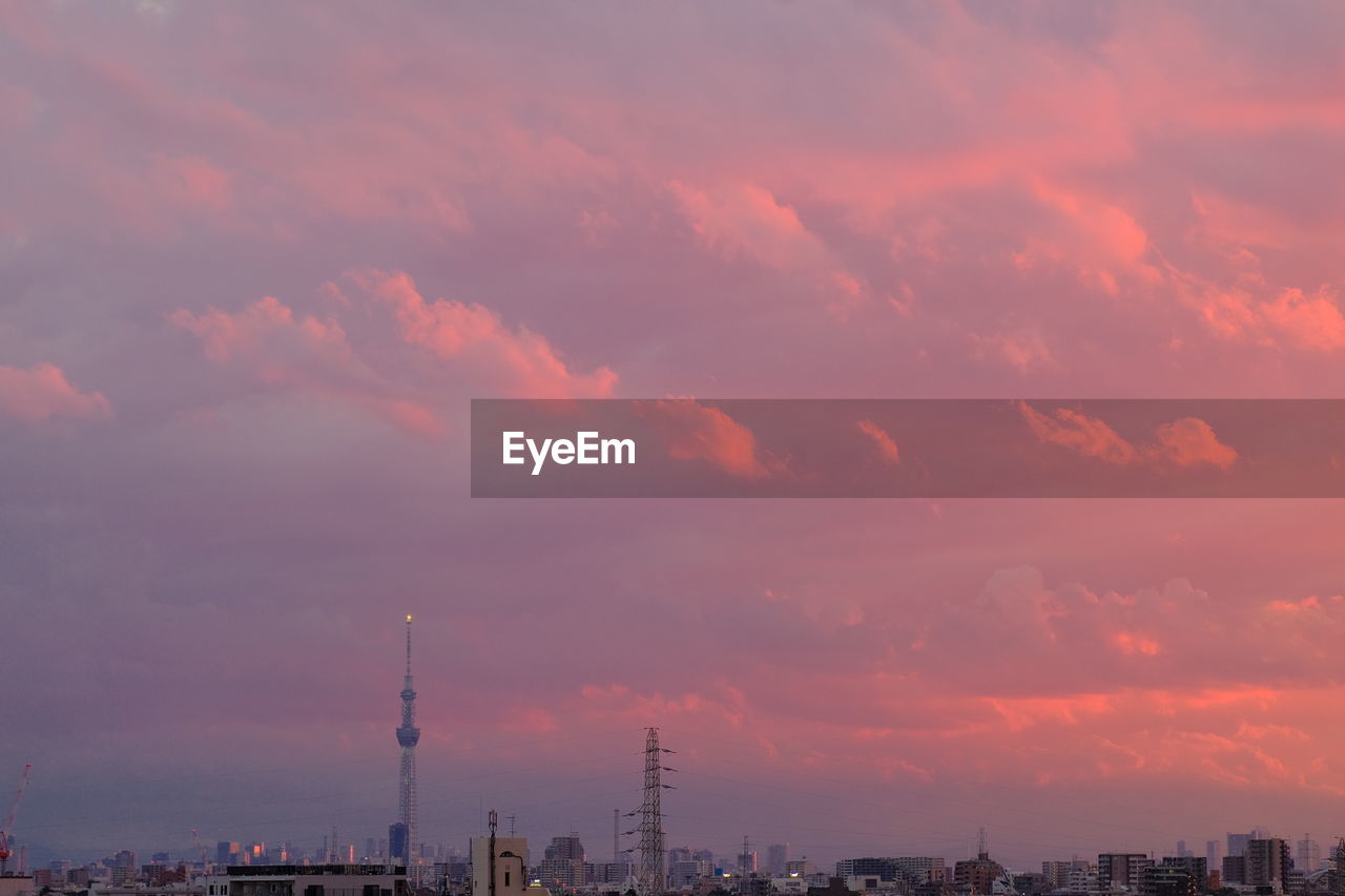 Low angle view of buildings against cloudy sky during sunset