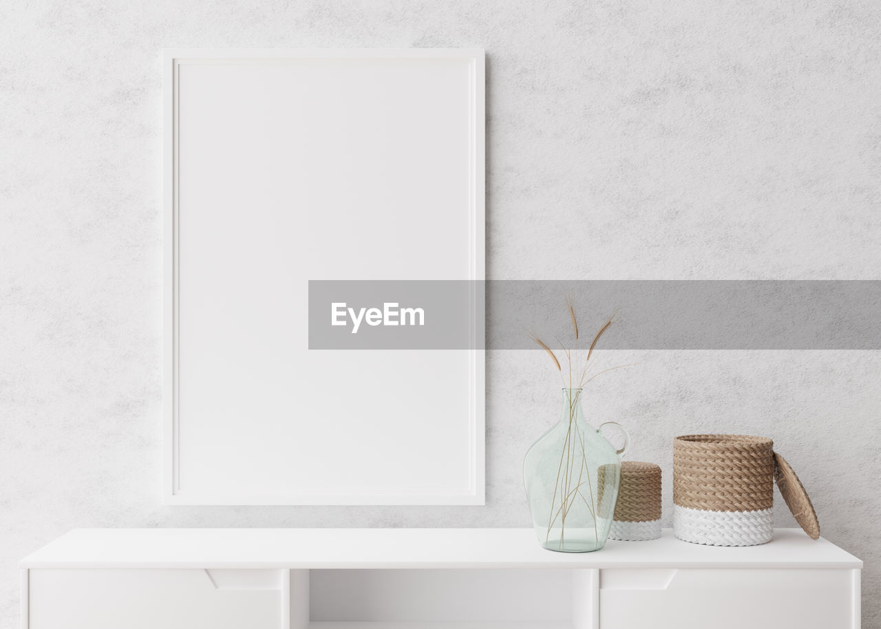 Empty vertical picture frame on white wall in modern living room. mock up interior  