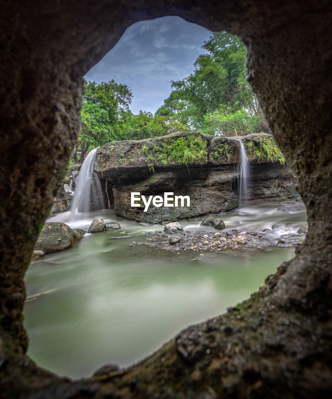 WATERFALL ALONG ROCKS AND PLANTS