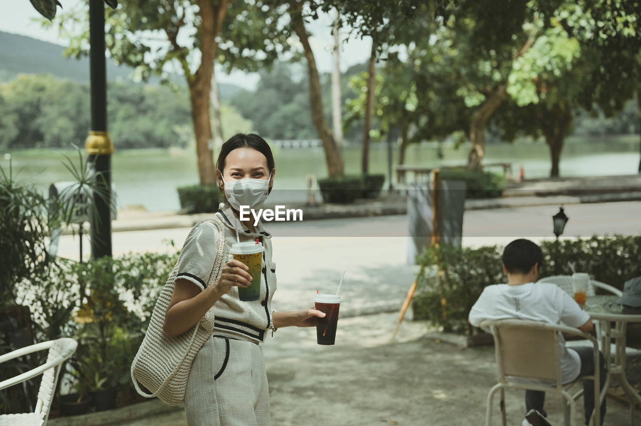Cinematic film style of confident young women carrying reusable bag and hand holding ice beverage