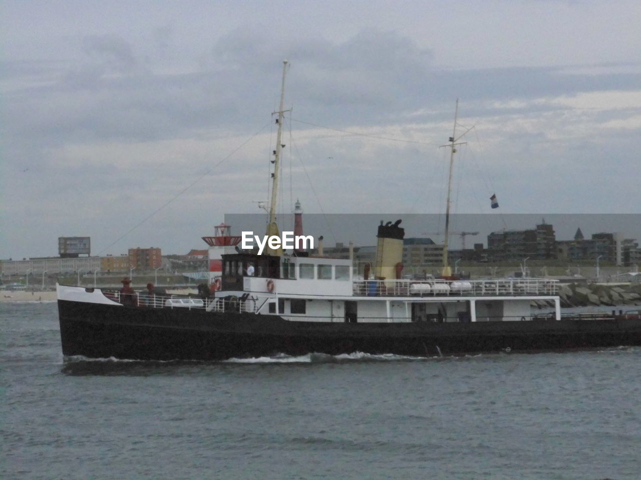 SHIP IN SEA WITH CITY IN BACKGROUND