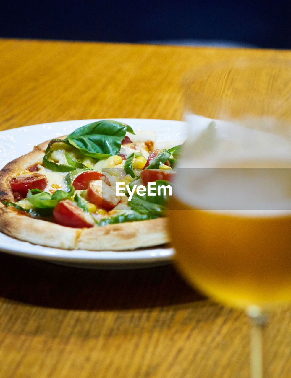 Close-up of pizza and beer served on table