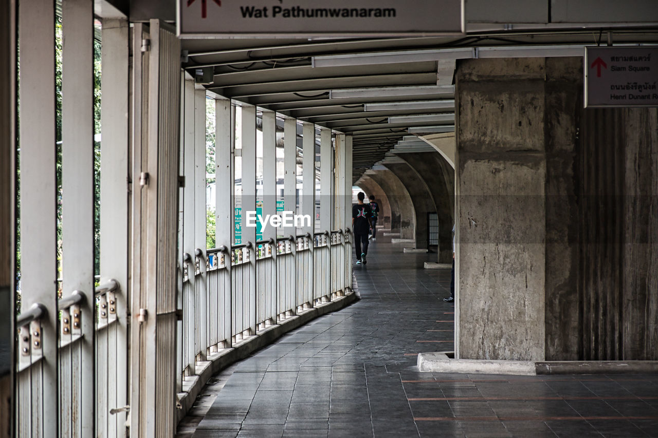 WOMAN WALKING IN BUILDING CORRIDOR