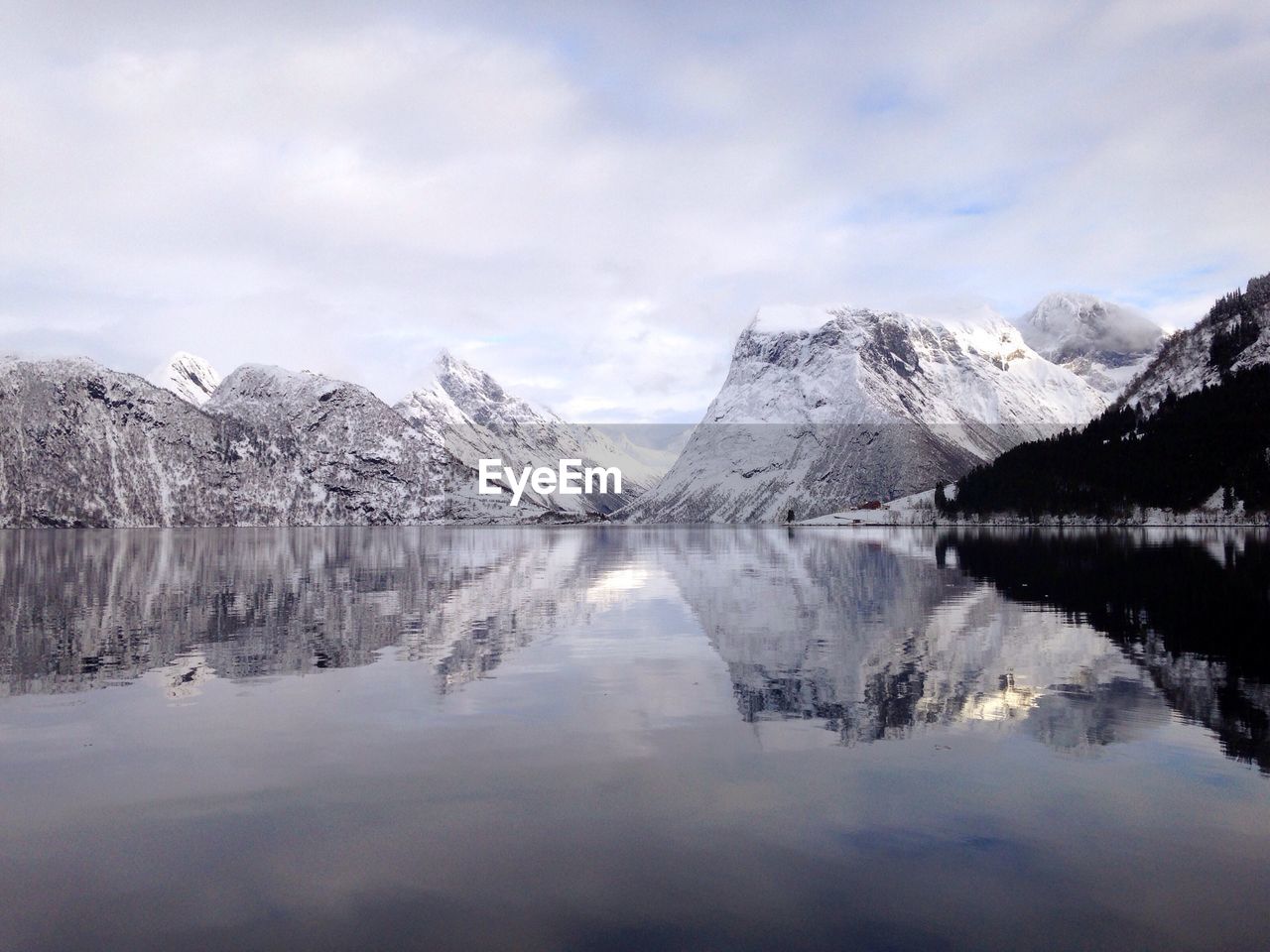 Scenic view of lake and snow covered mountains against sky