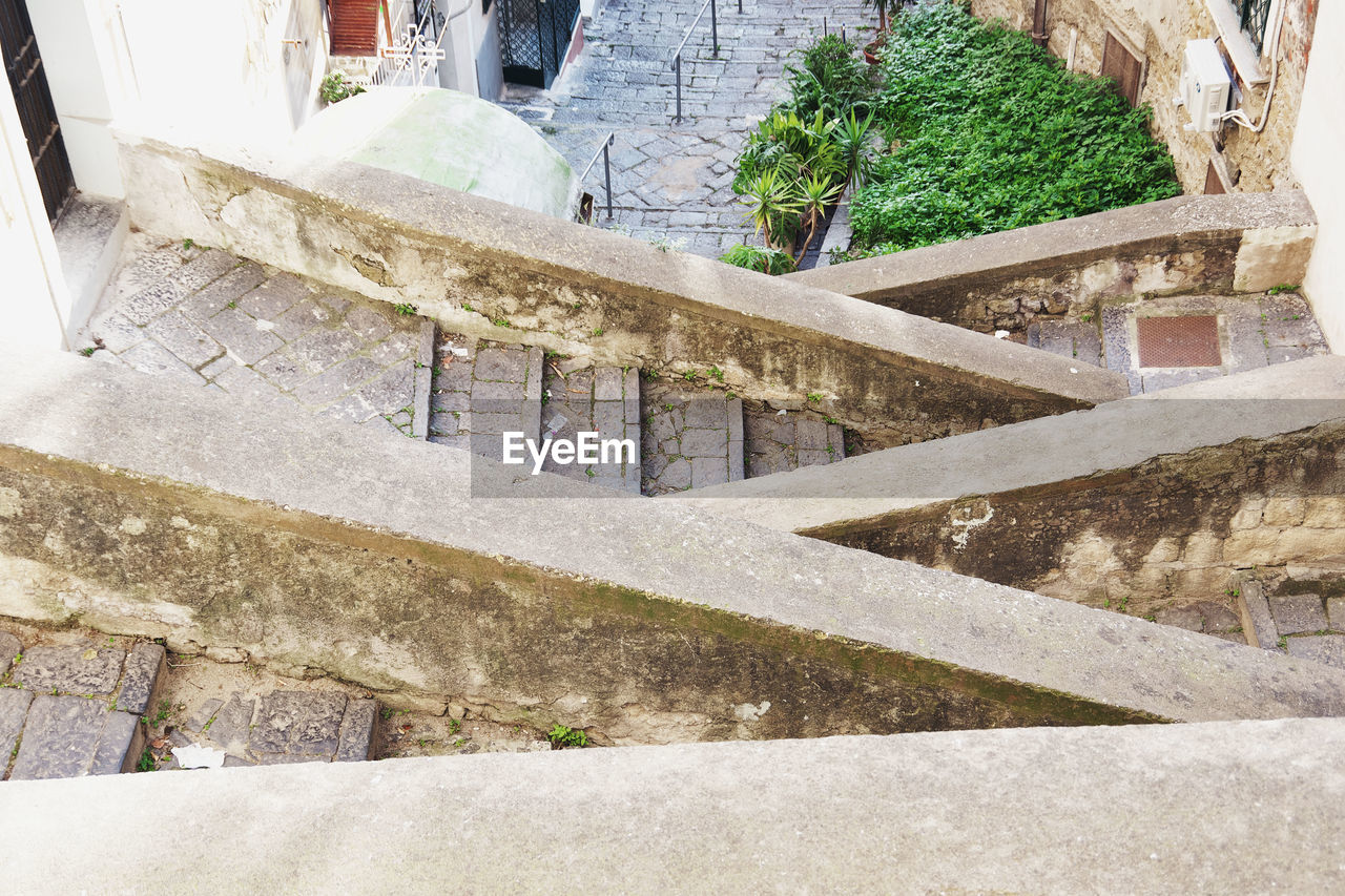 HIGH ANGLE VIEW OF STEPS BY STONE WALL