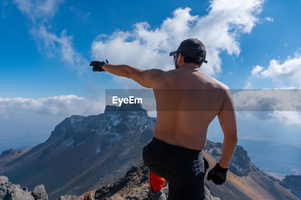 Rear view of shirtless man looking at mountain