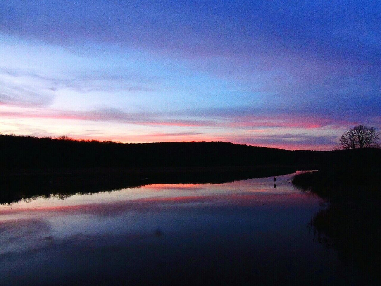 REFLECTION OF CLOUDS IN LAKE AT DUSK