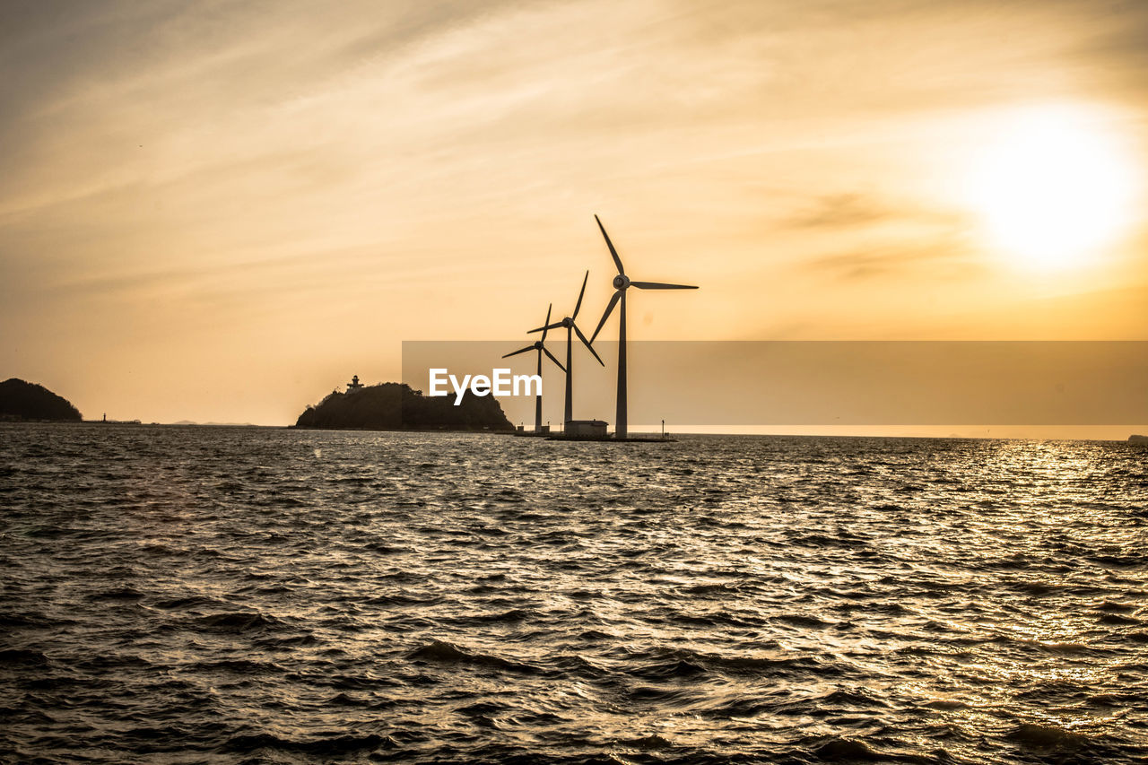 Silhouette of wind turbines at sunset