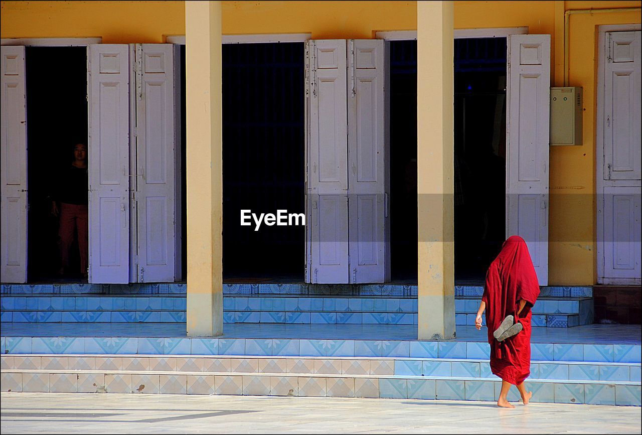 Rear view of woman walking towards steps