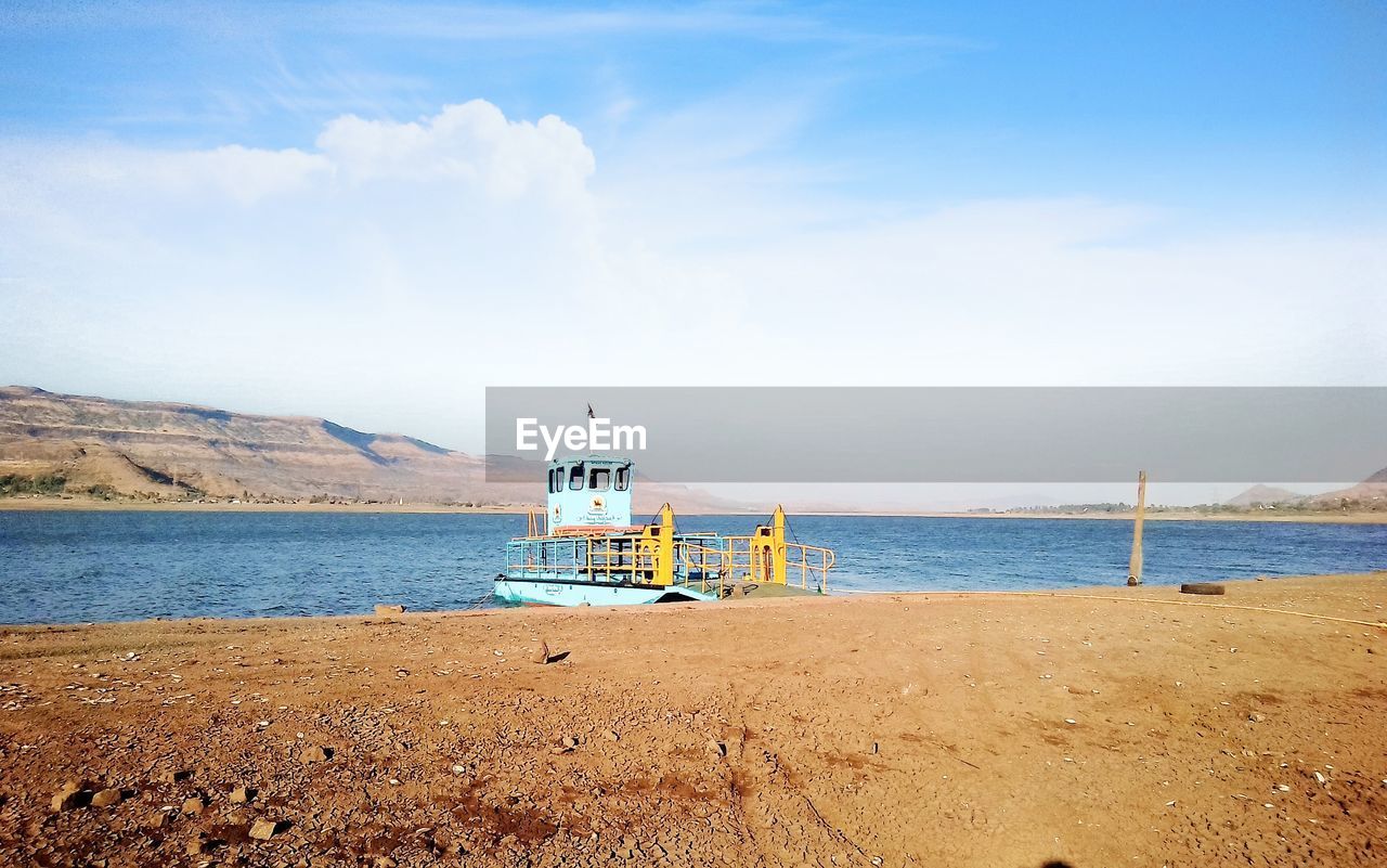 Scenic view of beach against sky lake side boat river sand 