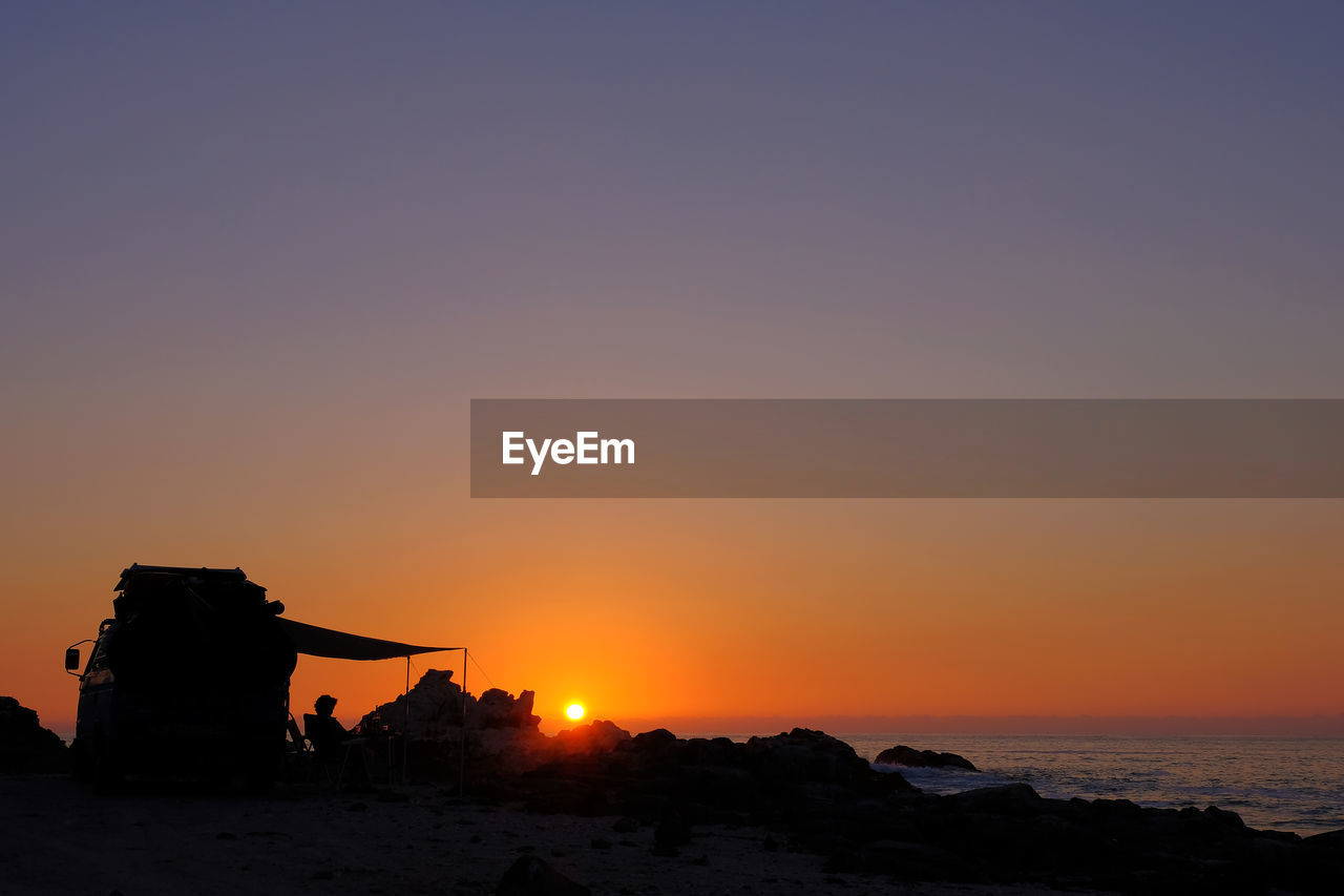 SILHOUETTE BEACH AGAINST SKY DURING SUNSET