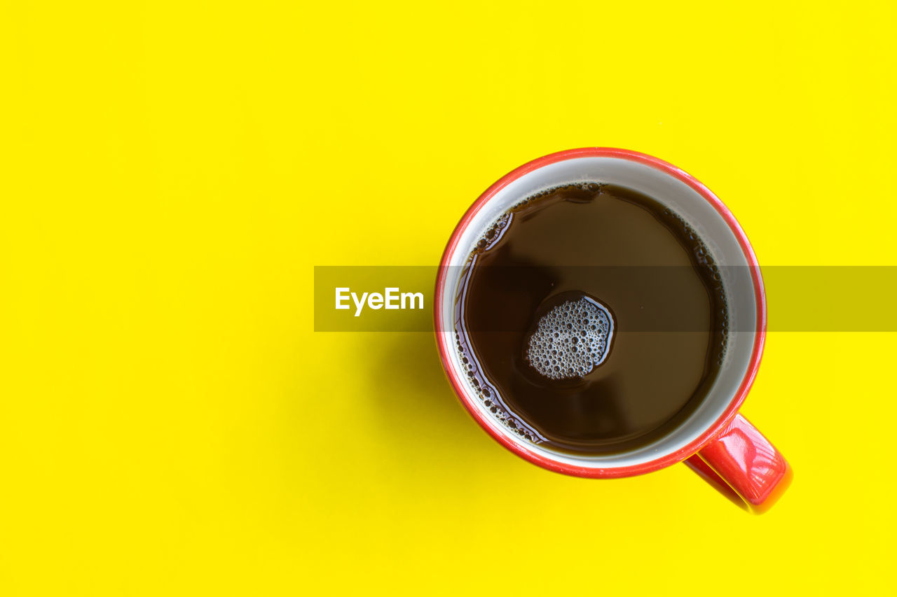 HIGH ANGLE VIEW OF COFFEE ON YELLOW BACKGROUND