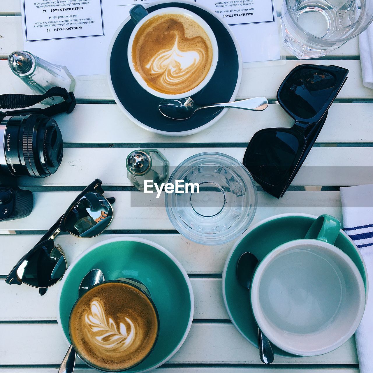 High angle view of sunglasses and coffee on wooden table