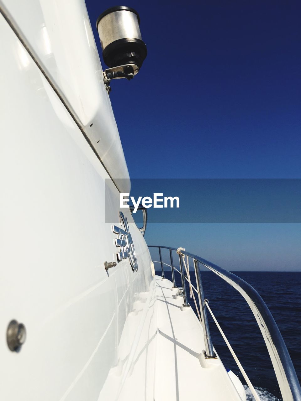 CLOSE-UP OF SAILBOAT SAILING IN SEA AGAINST CLEAR SKY