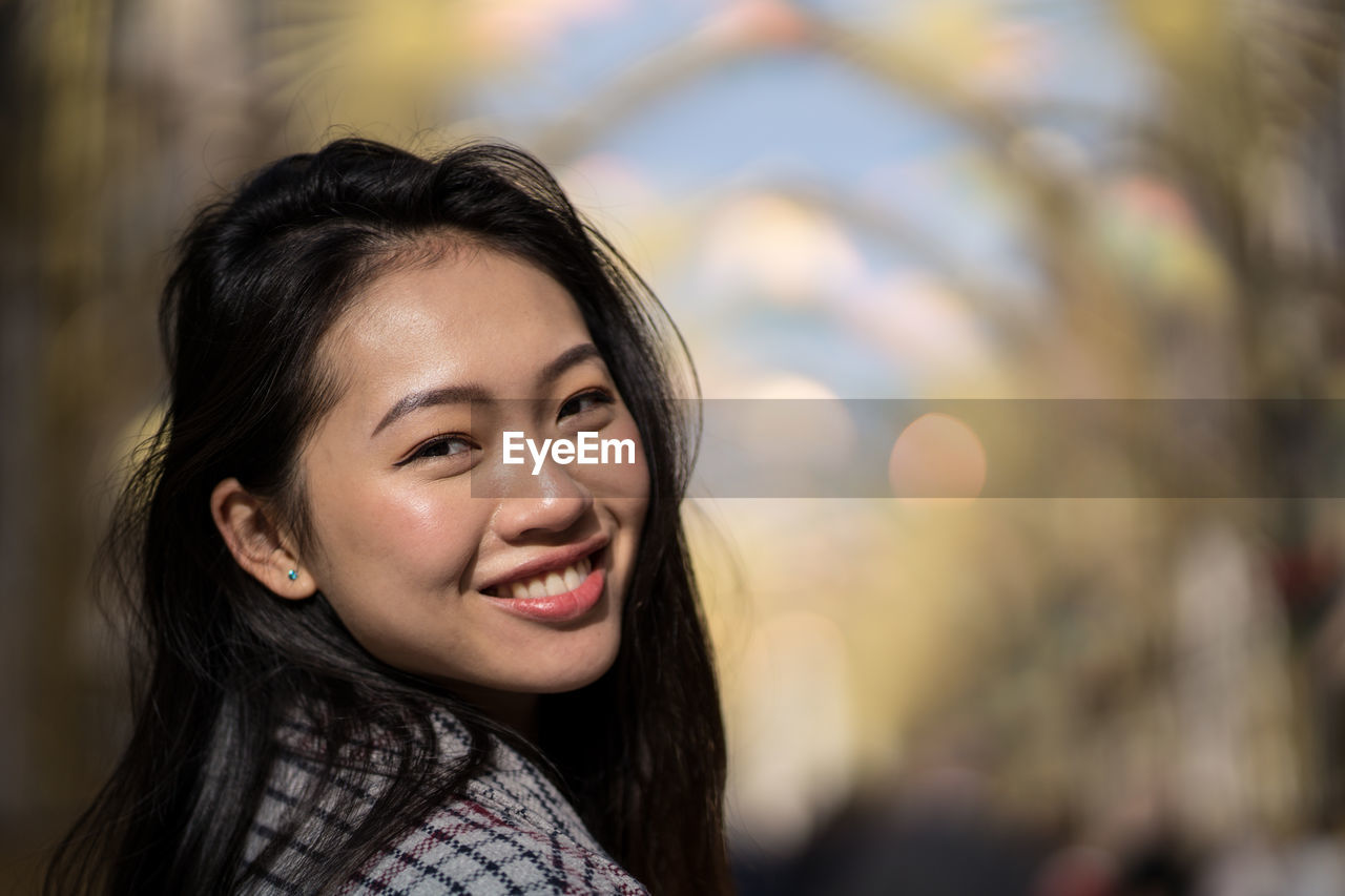 Happy ethnic young woman on street in downtown