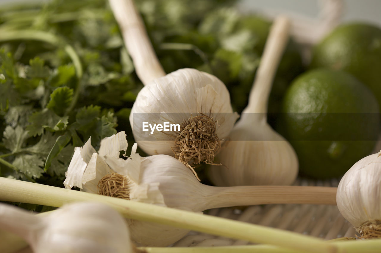 Close-up of garlic bulbs with cilantro and lemons on table