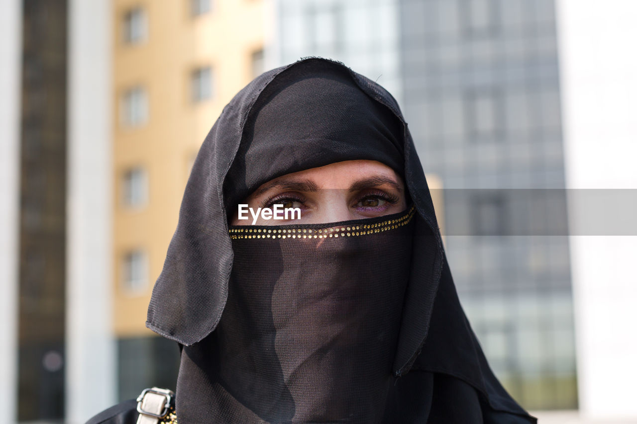 Muslim woman close-up portrait of her face black scarf on her head.