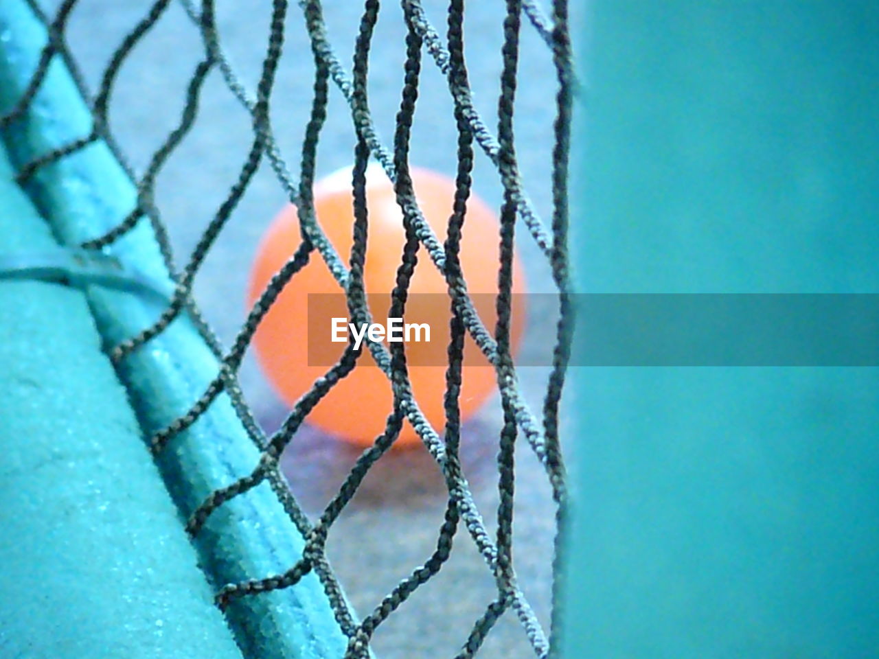 High angle view of ball seen through net