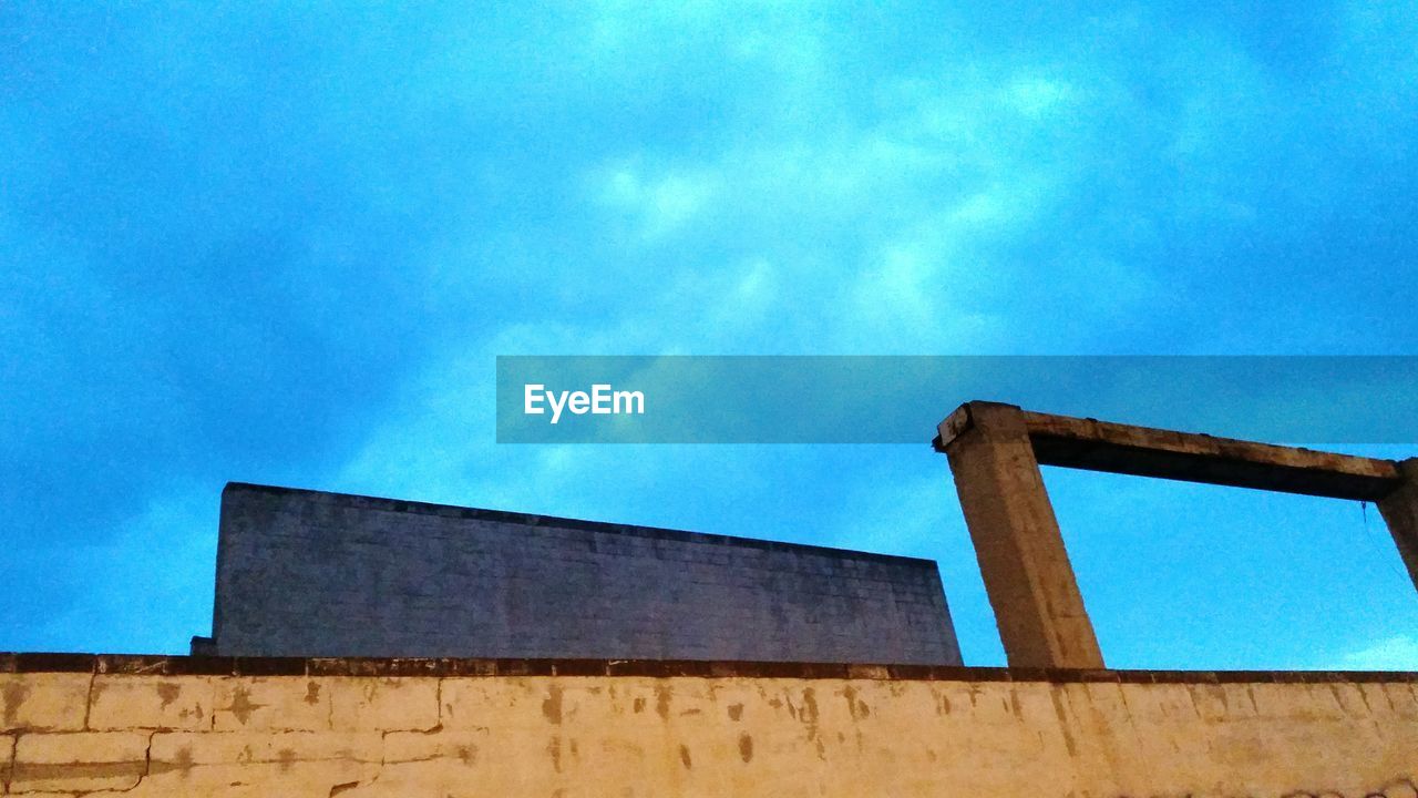 LOW ANGLE VIEW OF BUILT STRUCTURE AGAINST BLUE SKY