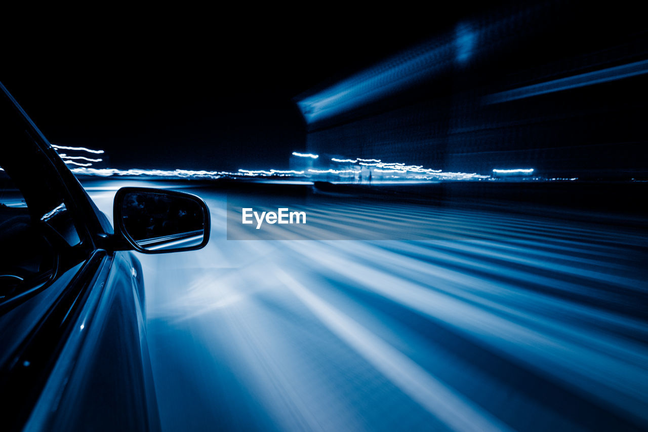 BLURRED MOTION OF CAR ON ROAD AT NIGHT