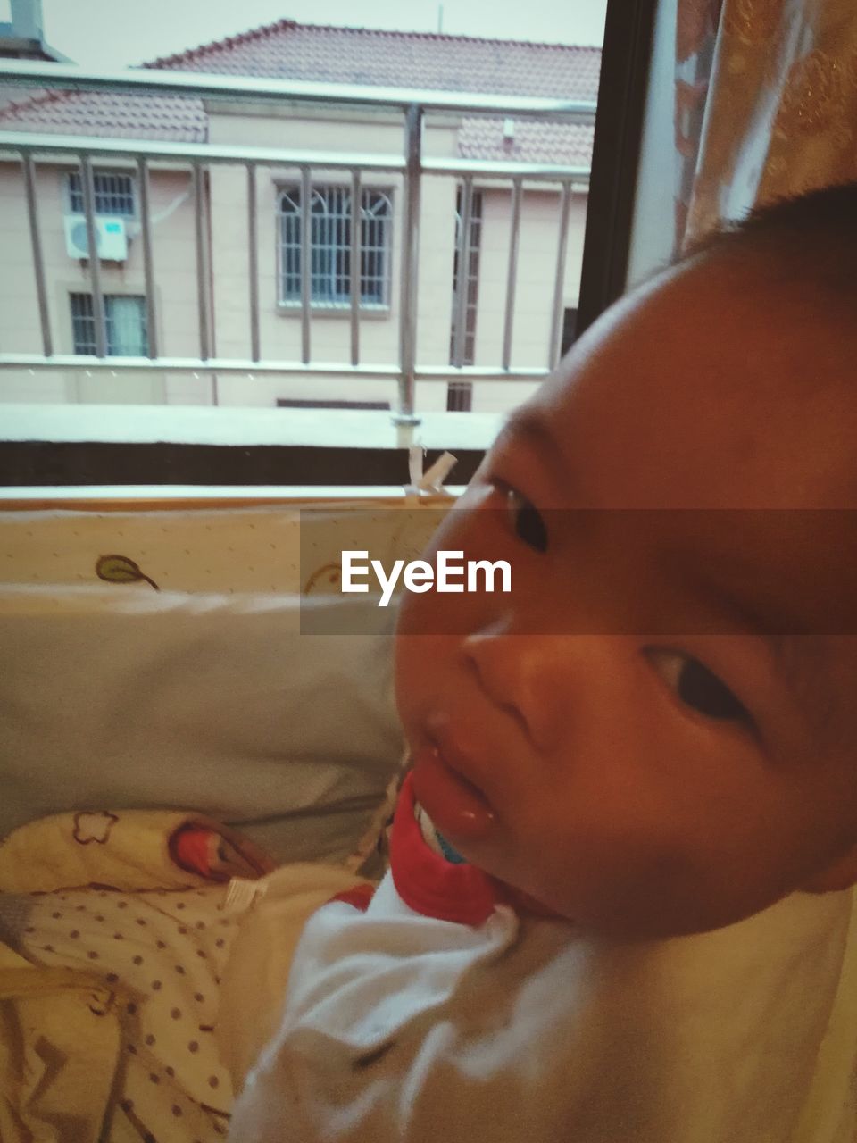 CLOSE-UP OF CUTE BOY AT HOME WINDOW