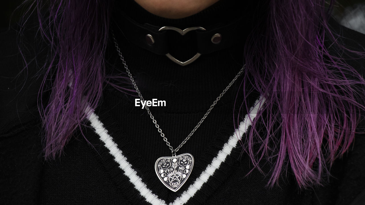 necklace, purple, jewelry, one person, fashion accessory, jewellery, adult, front view, pink, midsection, chain, portrait, pendant, women, fashion, indoors, studio shot, heart shape, close-up, locket, black background, person, clothing