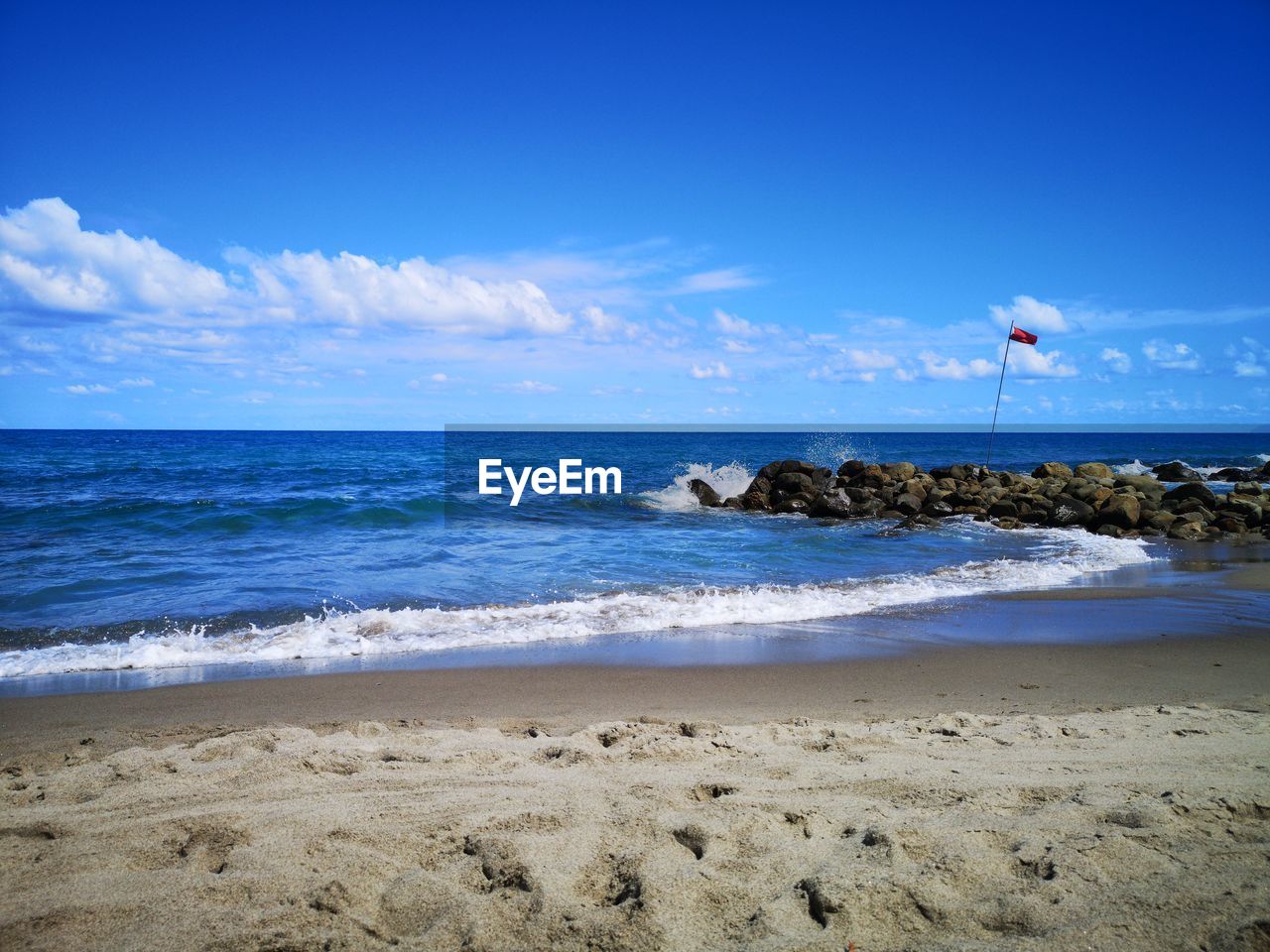 SCENIC VIEW OF BEACH AGAINST BLUE SKY